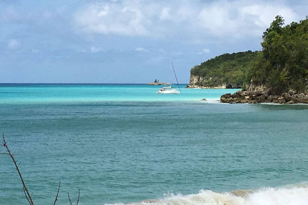 Un voilier au mouillage dans une anse aux eaux turquoise de Marie-Galante